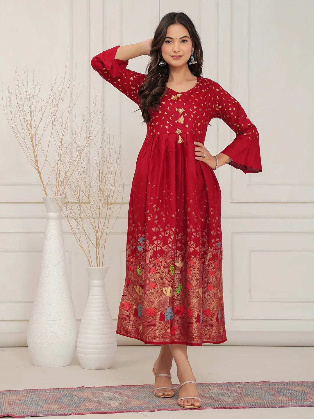 Woman wearing a red dress with floral patterns in a minimalistic setting