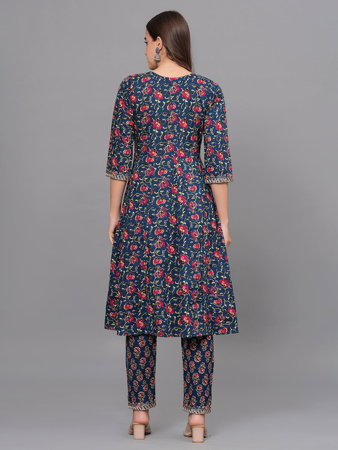 Woman wearing a navy blue floral kurta with pants on a gray background
