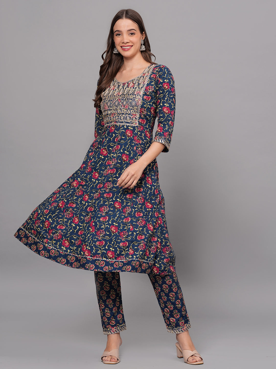 Woman wearing a navy floral kurta with matching pants on a gray background
