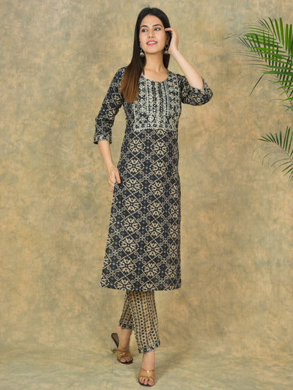 Woman wearing a black and white patterned kurta with palazzo pants against a beige background.