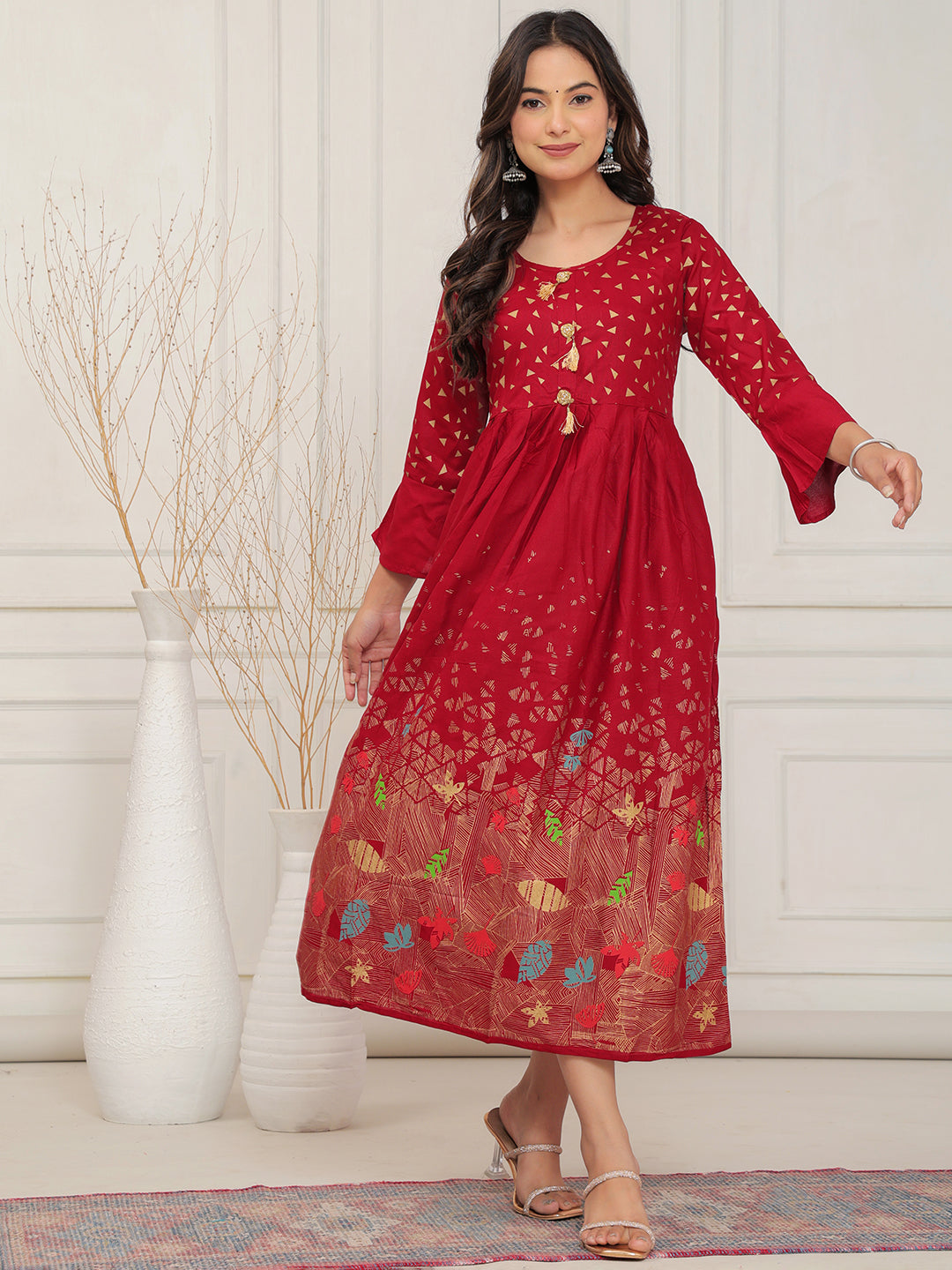 Woman wearing a red dress with floral patterns in a minimalistic setting