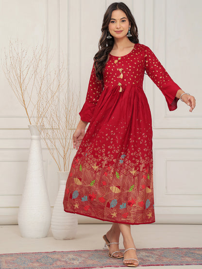 Woman wearing a red dress with floral patterns in a minimalistic setting