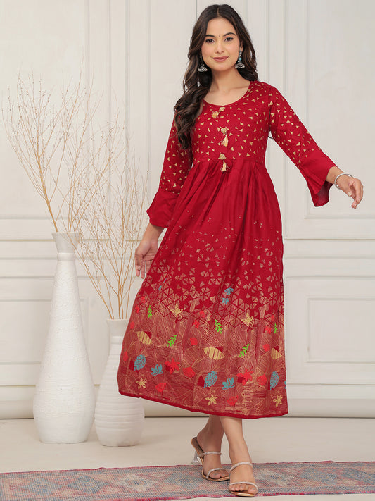 Woman wearing a red dress with floral patterns in a minimalistic setting