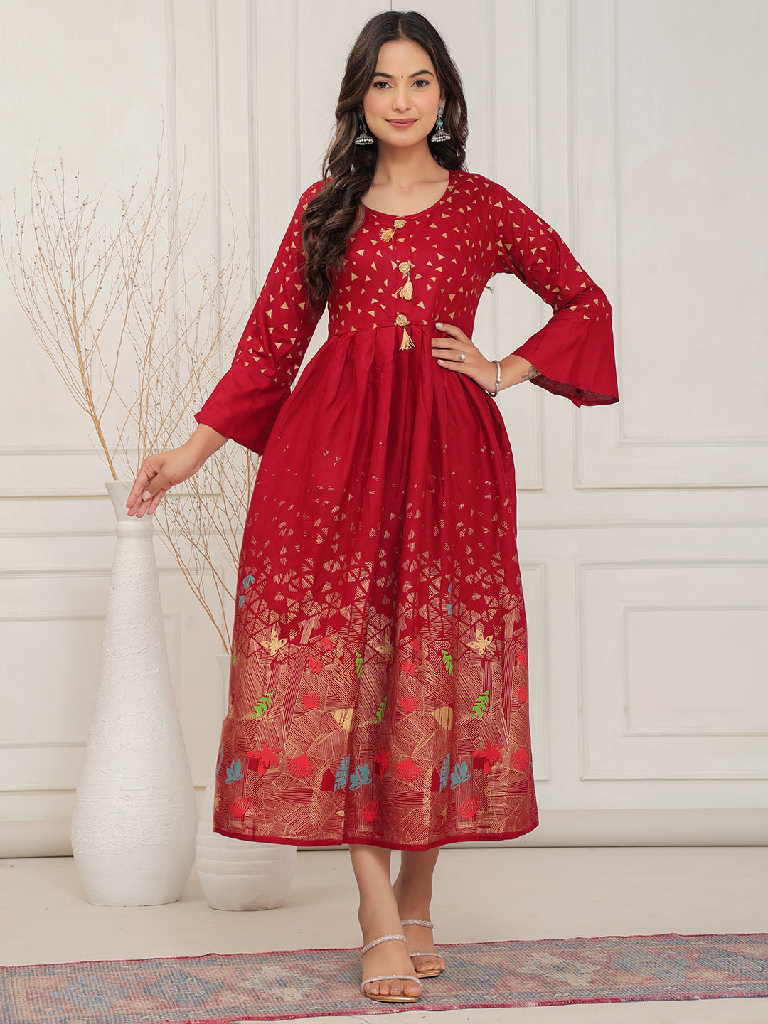 Woman wearing a red dress with floral patterns in a minimalistic setting