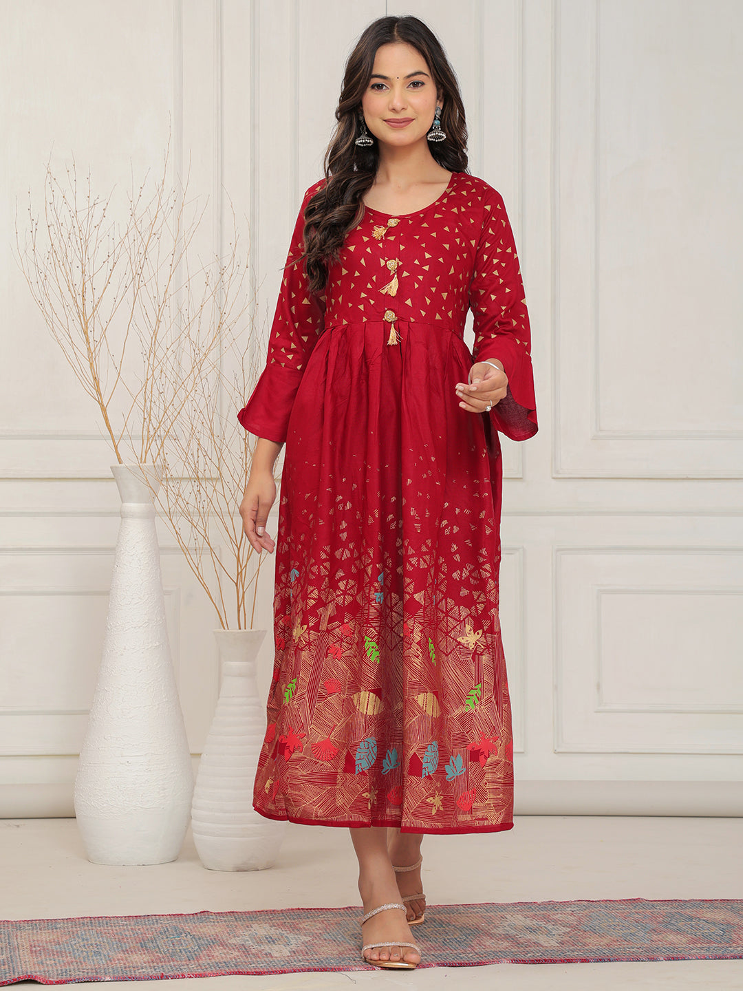 Woman wearing a red dress with floral patterns in a minimalistic setting