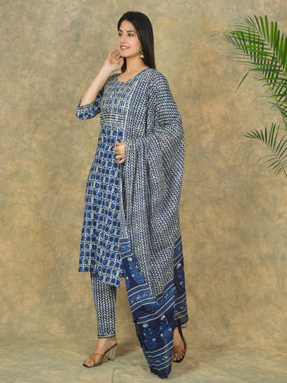 Woman wearing a blue and white patterned outfit against a beige background