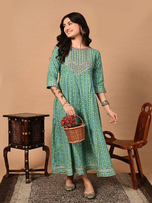 Woman in a green patterned dress holding a basket of flowers against a beige background