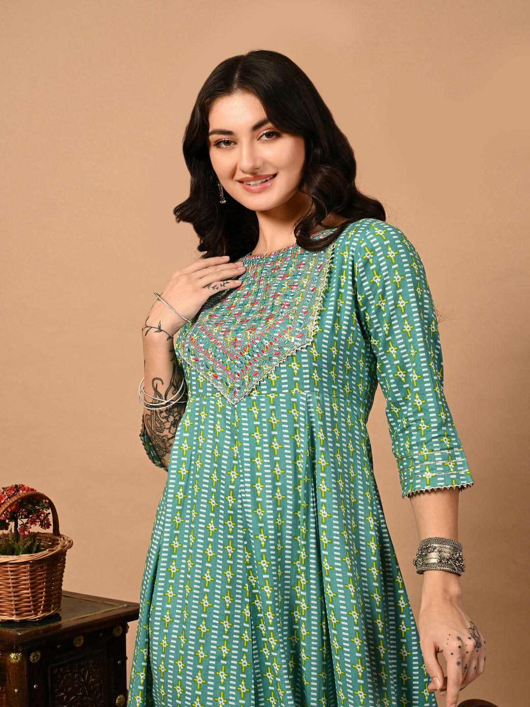Woman wearing a green patterned dress with a brown background