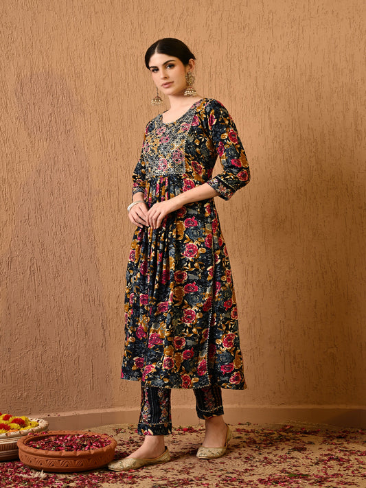 Woman wearing a floral dress standing against a beige wall.