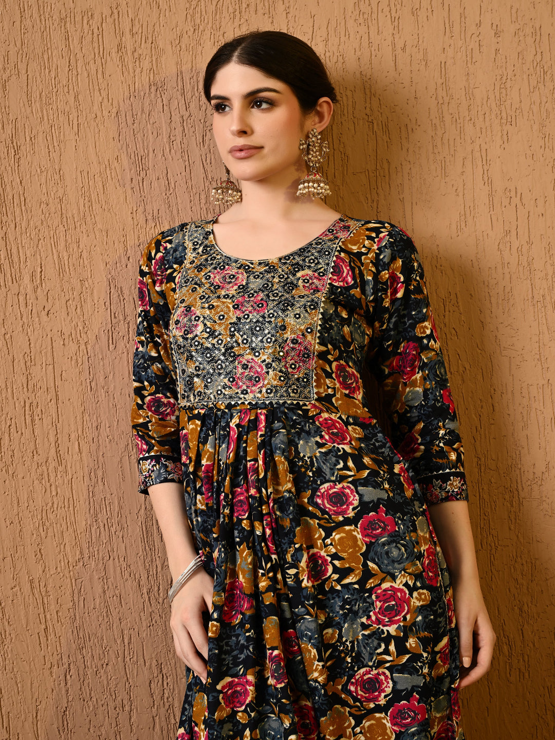 Woman wearing a floral dress against a wooden wall
