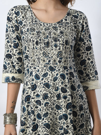 Woman wearing a patterned dress with blue and black design on a white background