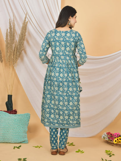 Woman wearing a blue floral kurta with white pants against a beige background