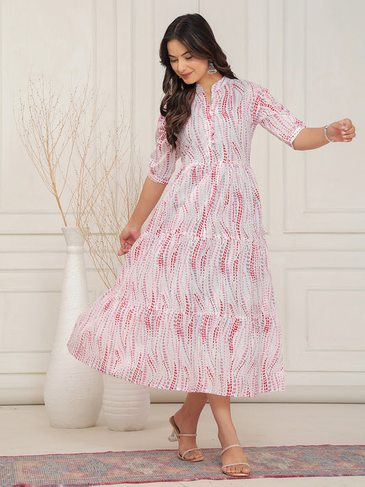 Woman wearing a white dress with red patterns in a minimal indoor setting