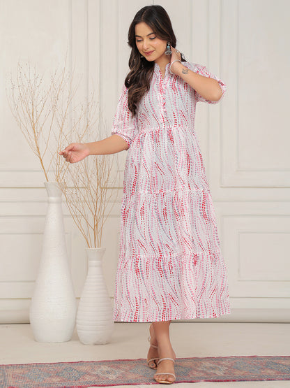 Woman wearing a white dress with red patterns in a room with decorative vases.