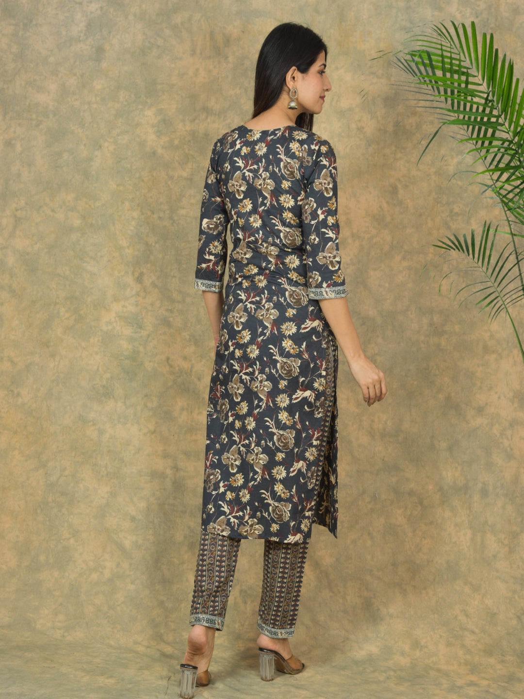 Woman wearing a floral kurta with a textured brown background