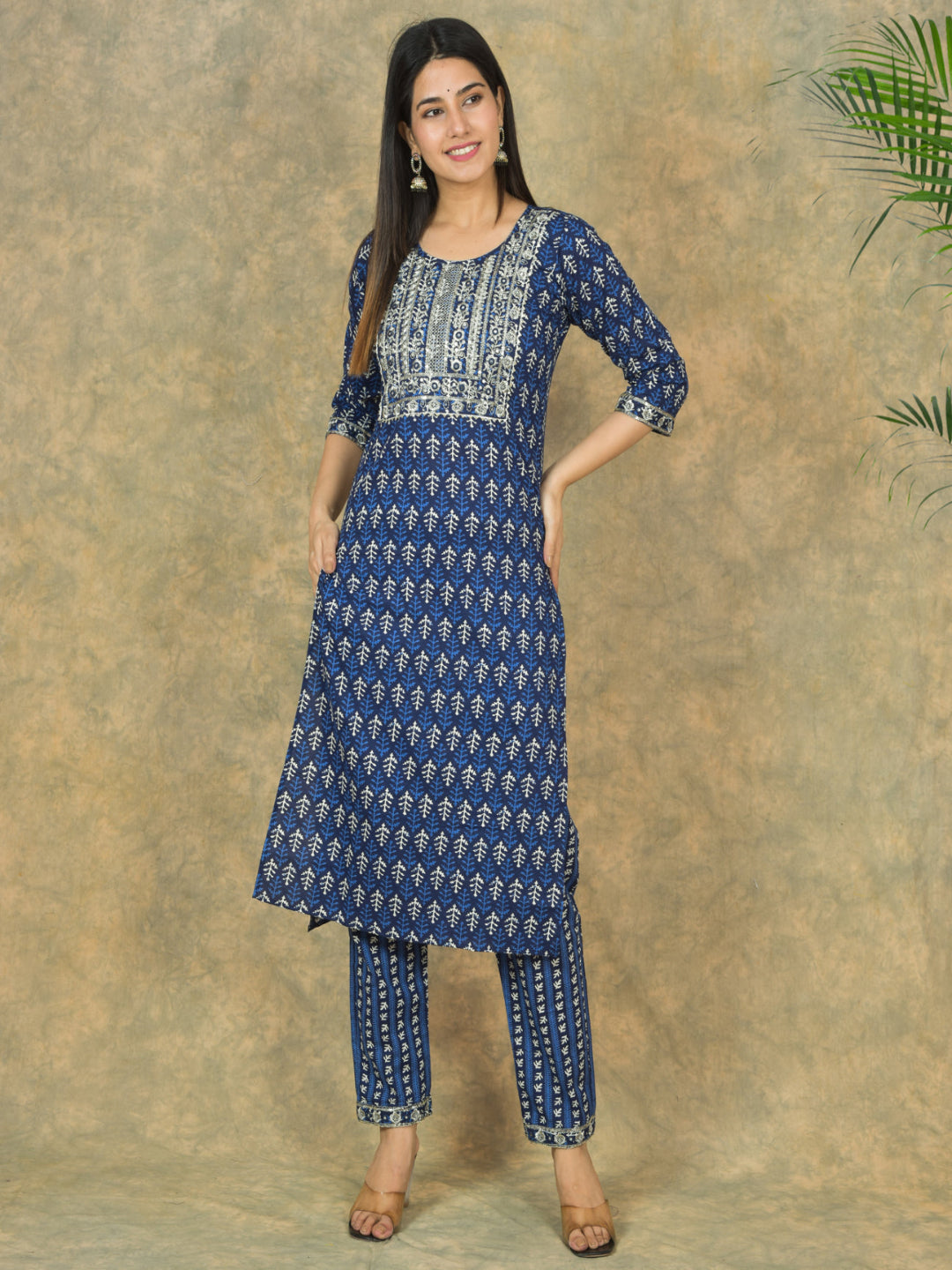 Woman wearing a blue patterned kurta with palazzo pants against a beige background