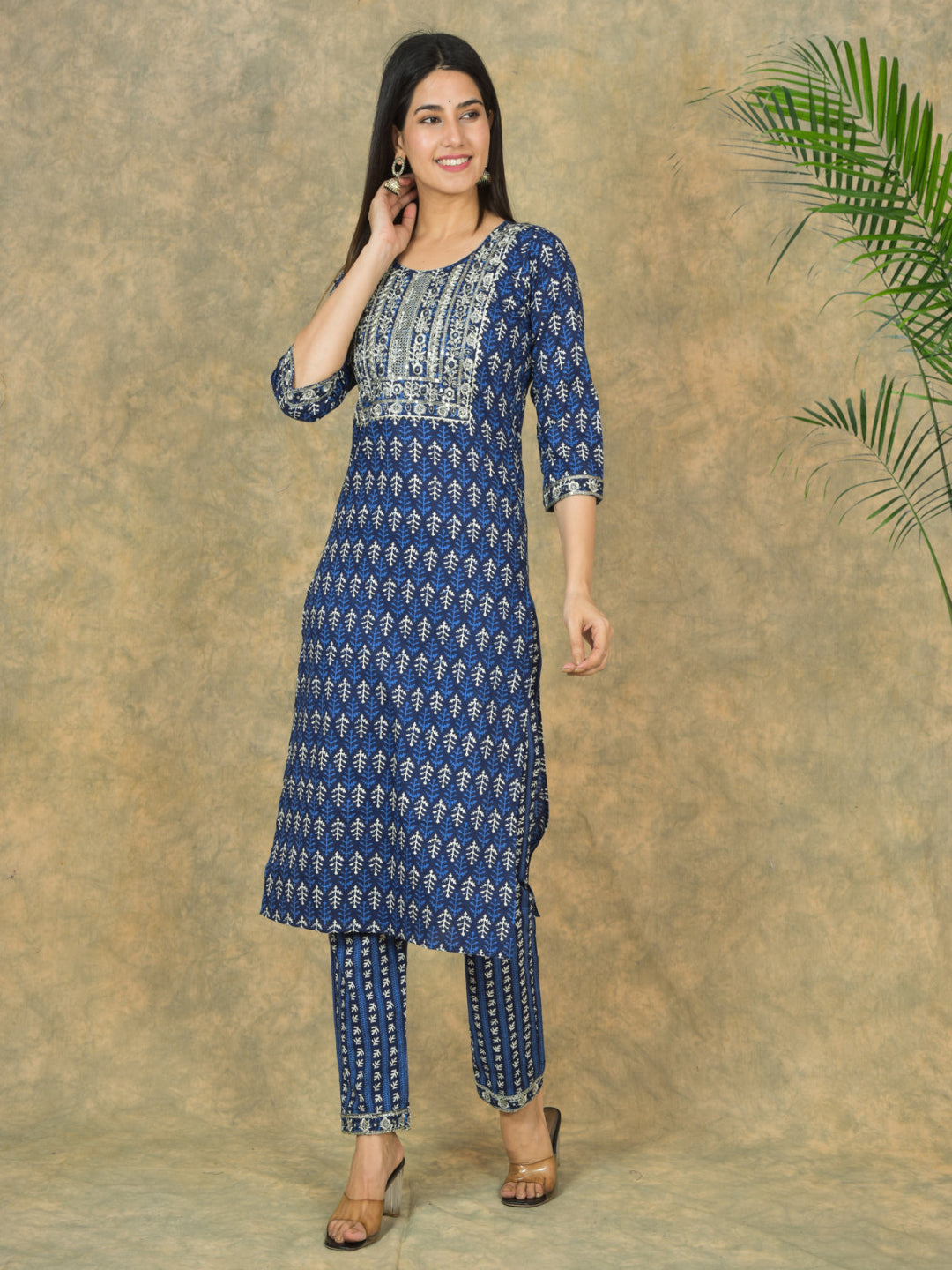 Woman wearing a blue and white patterned kurta with pants against a beige background