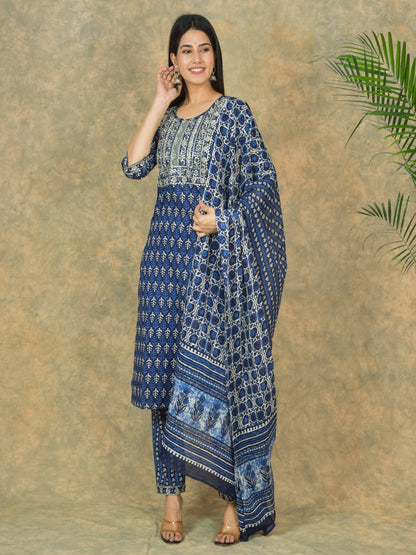 Woman wearing a blue patterned outfit against a beige background