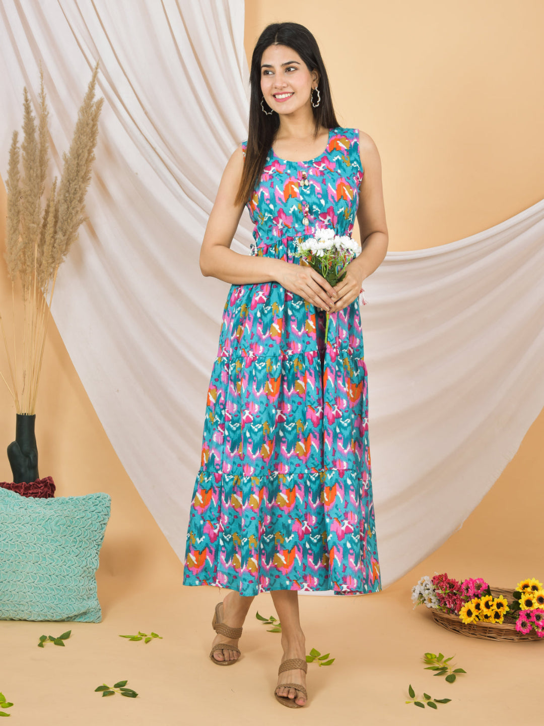 Woman wearing a colorful floral dress holding flowers against a beige background
