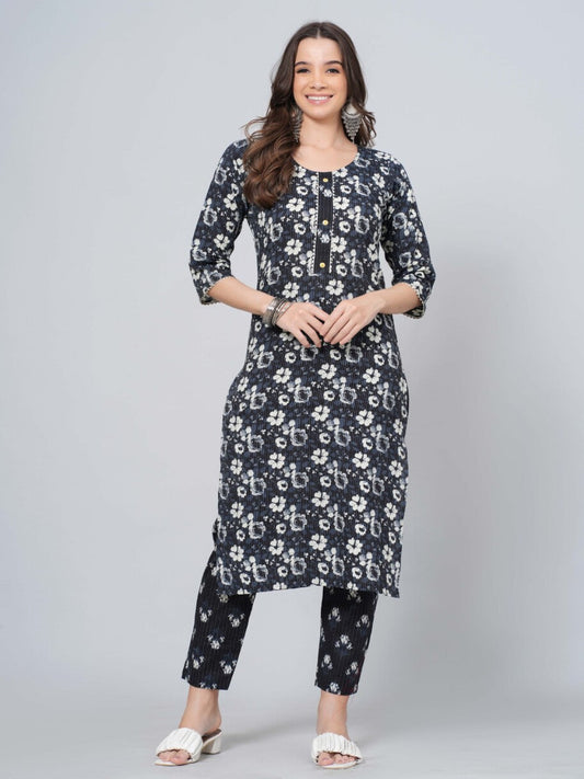 Woman wearing a black floral printed outfit on a gray background