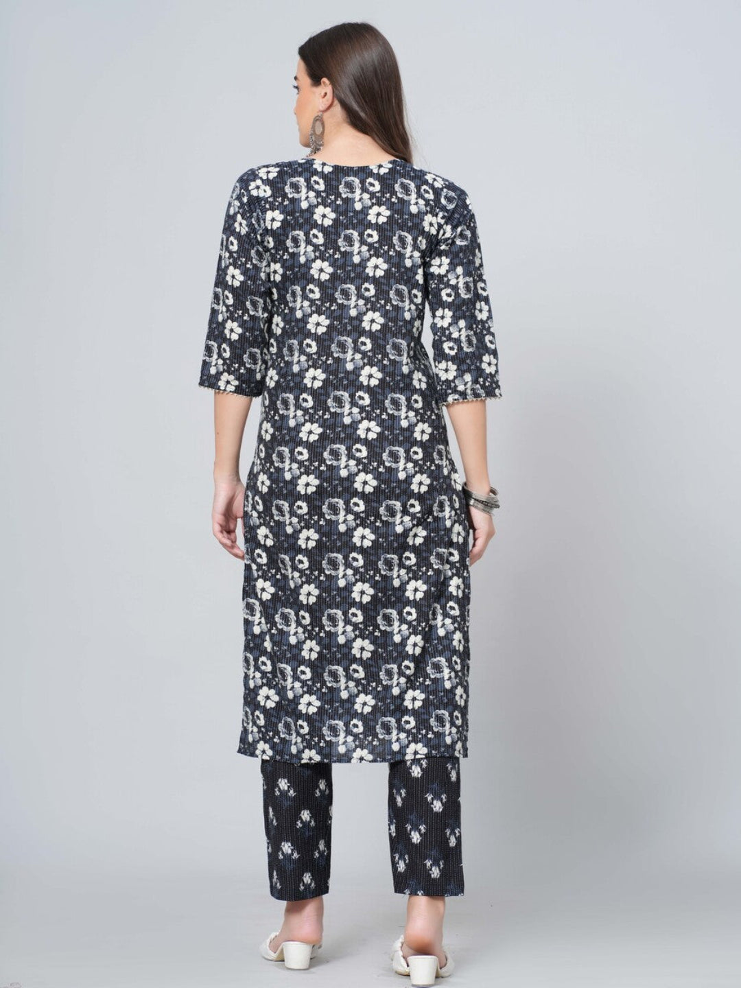 Woman wearing a black floral kurta with matching pants on a white background