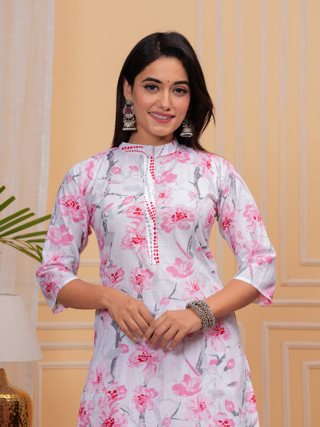 Woman wearing a floral dress with a beige wall background