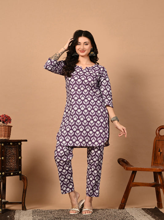 Woman wearing a patterned outfit standing against a beige background