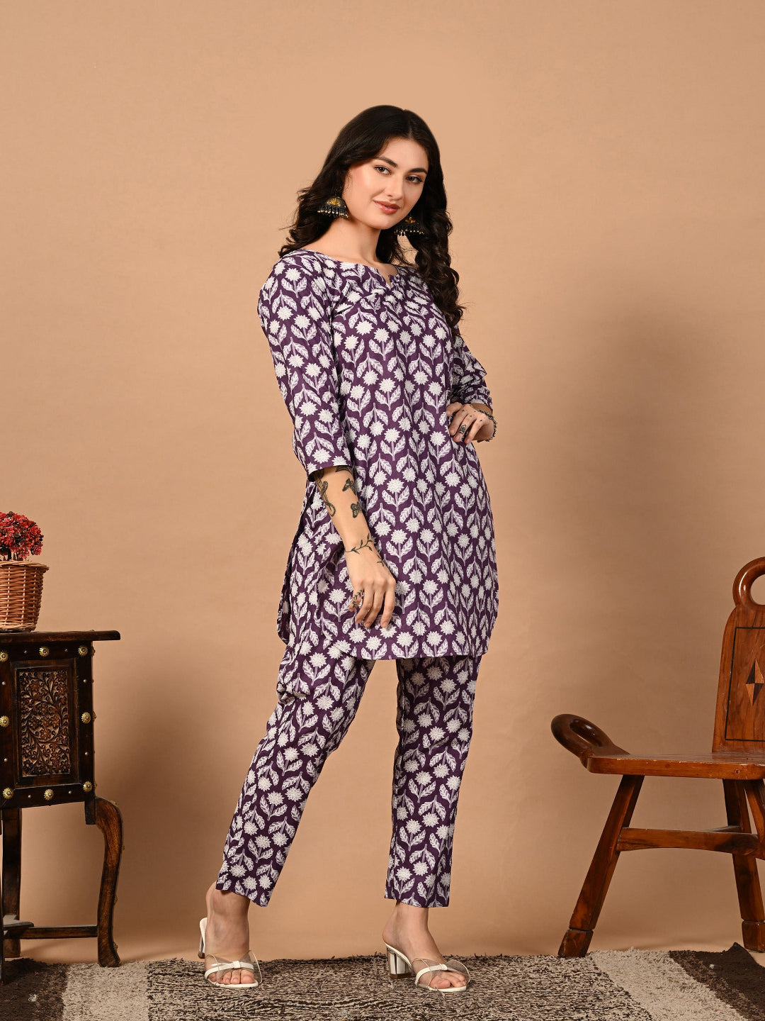 Woman wearing a patterned kurta with pants against a beige background