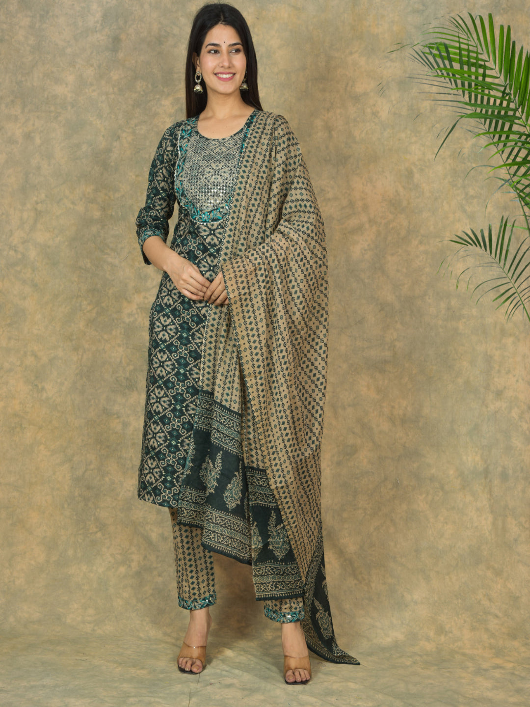 Woman wearing a traditional outfit with a patterned shawl against a beige background