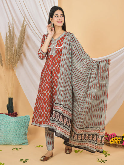 Woman wearing a traditional outfit with a red and white top and patterned pants on a beige background. > Mitrika