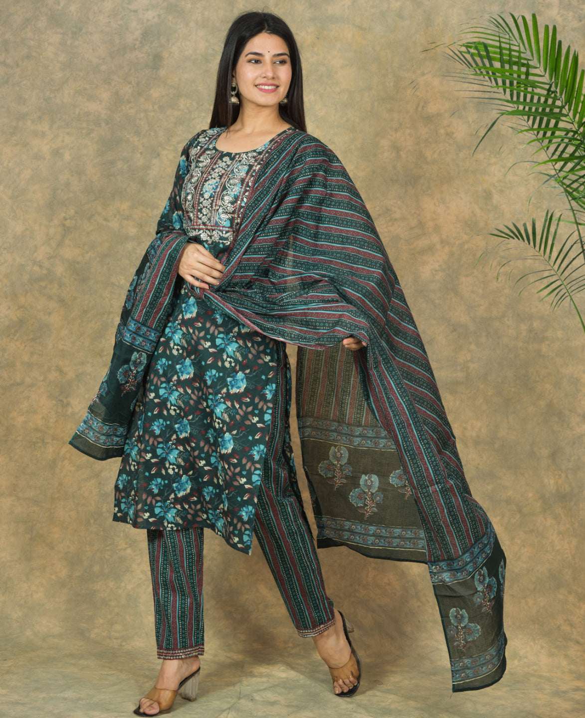 Woman wearing a traditional outfit with a floral shawl against a beige background