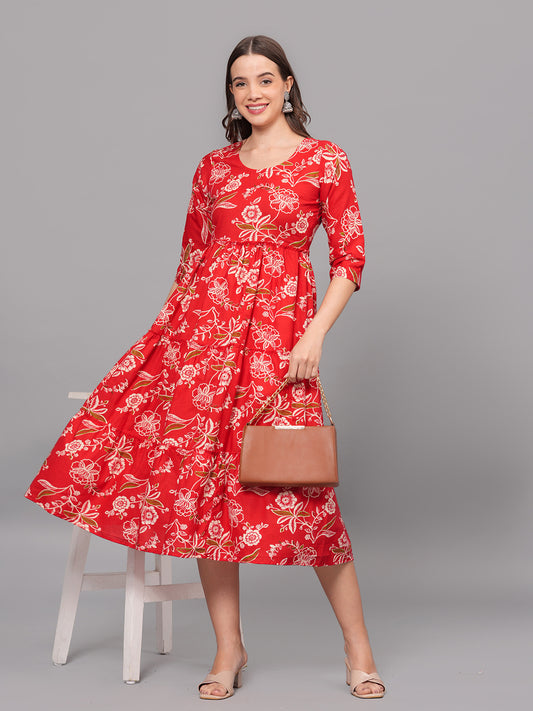 Woman wearing a red floral dress holding a brown handbag on a gray background > Mitrika