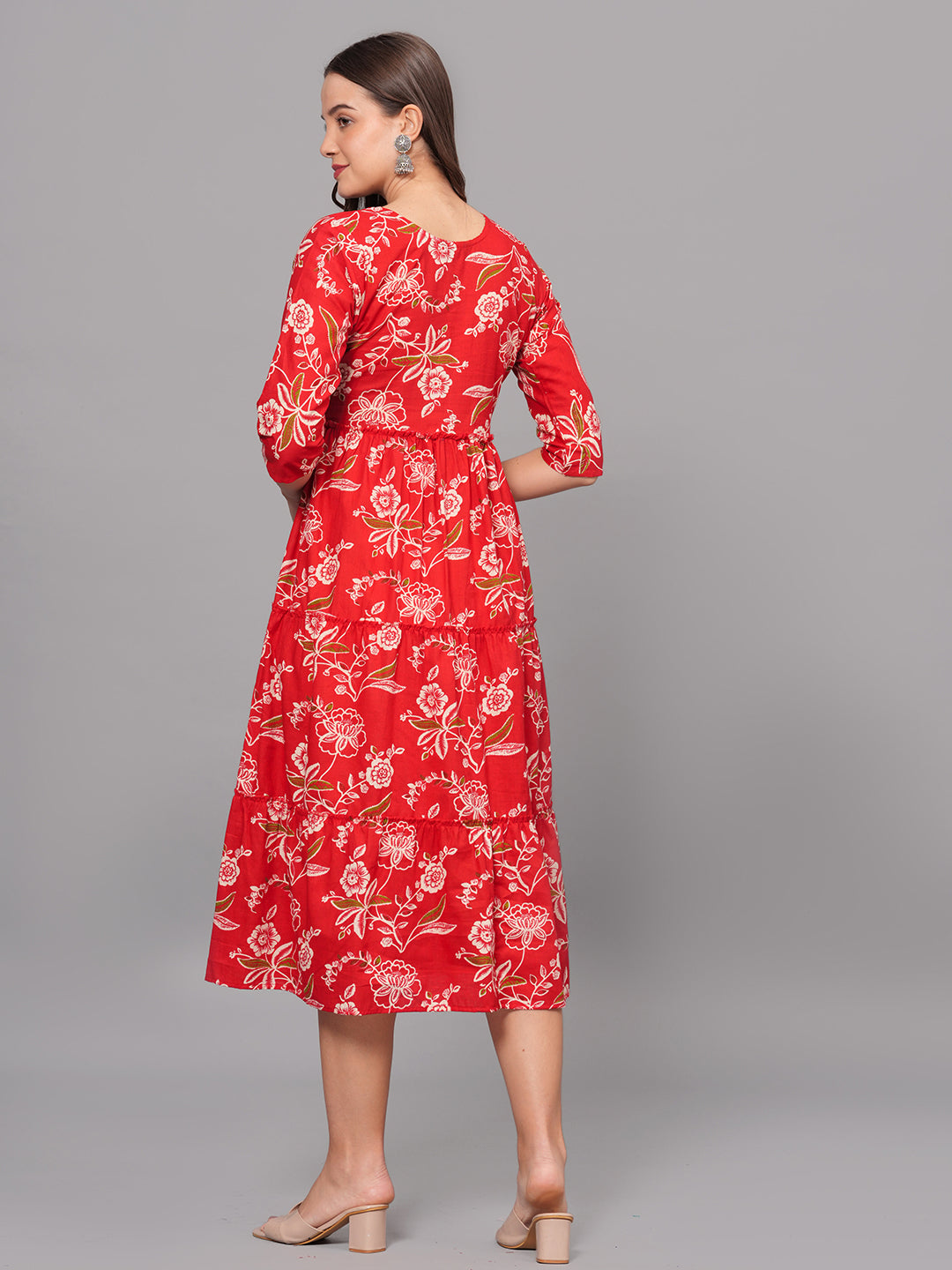 Woman wearing a red floral dress on a gray background
