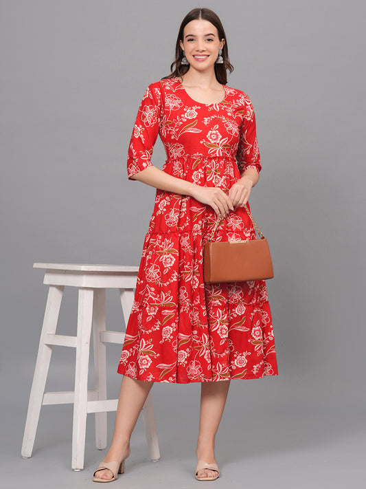 Woman wearing a red floral dress holding a brown handbag on a gray background