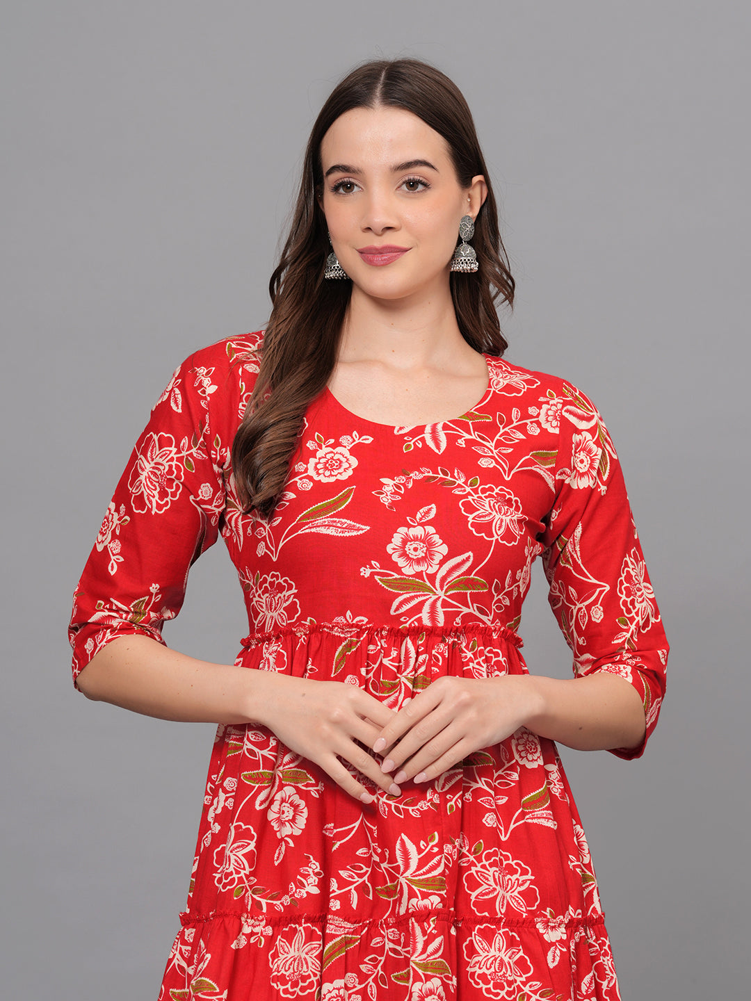 Woman wearing a red floral dress against a gray background