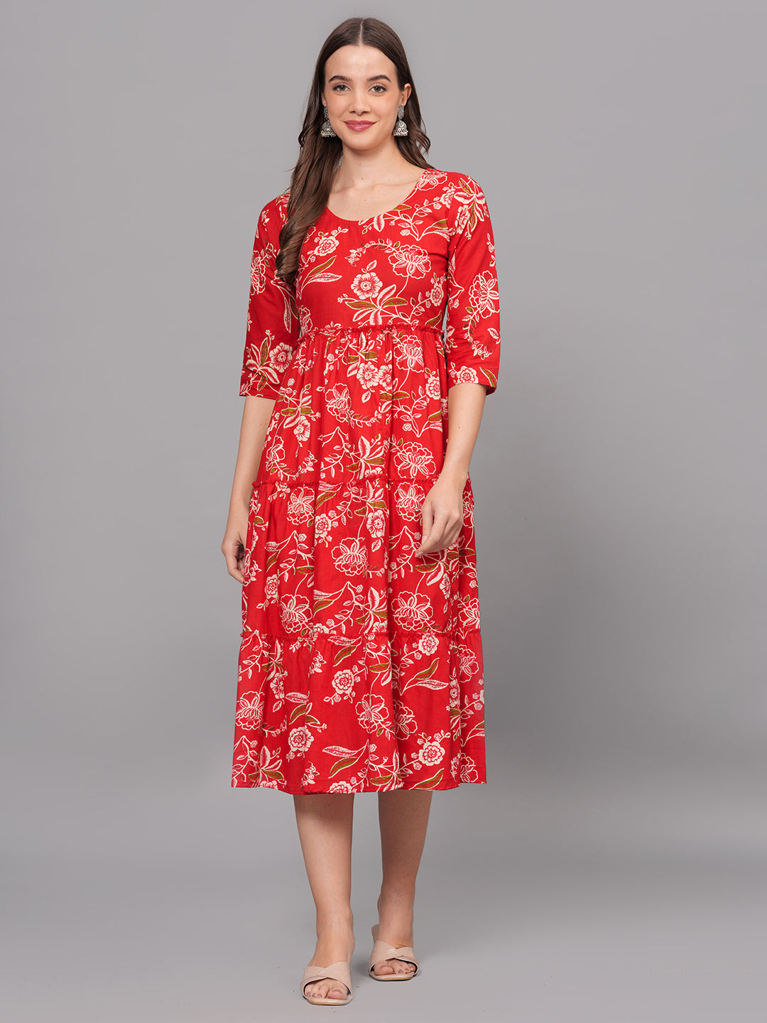 Woman wearing a red floral dress on a gray background