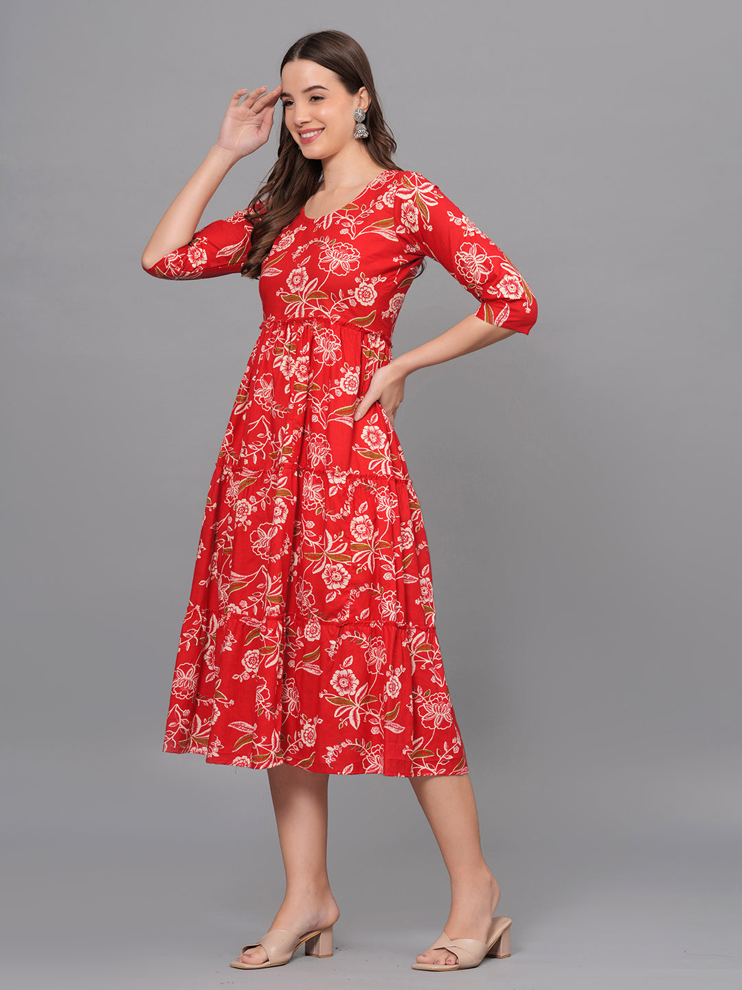 Woman wearing a red floral dress against a gray background