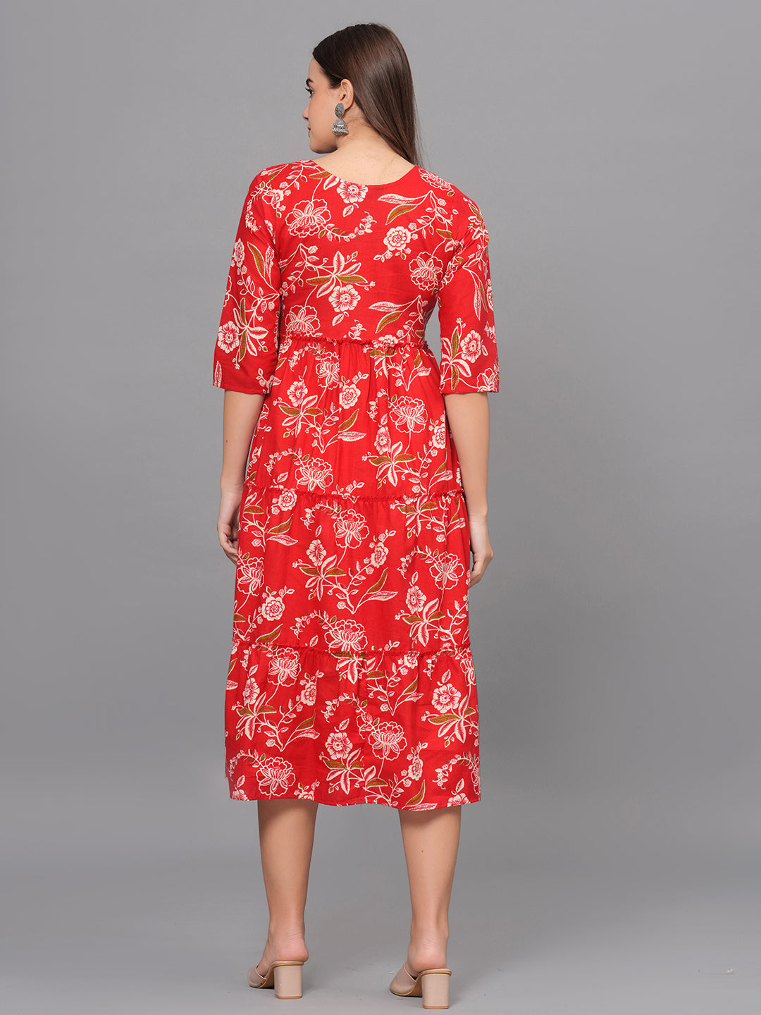 Woman wearing a red floral dress on a gray background