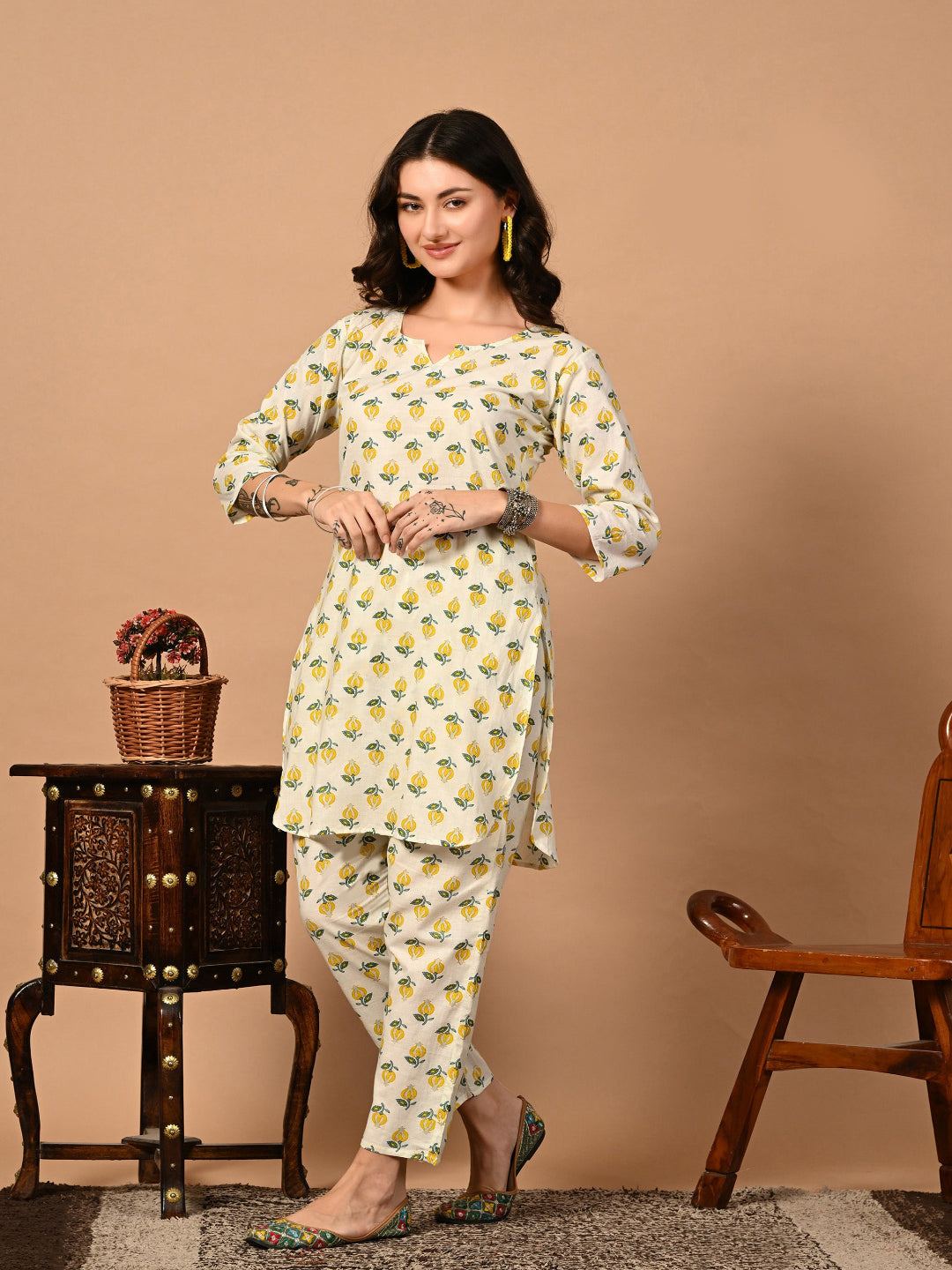Woman wearing a floral kurta with pants against a beige background