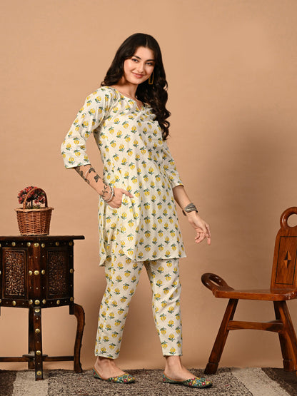 Woman wearing a floral outfit standing against a beige background