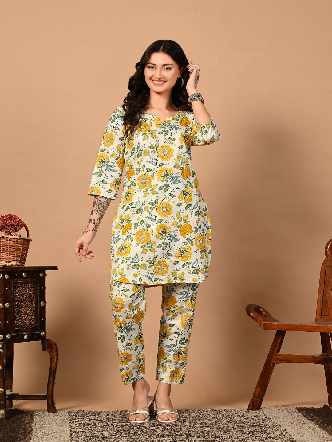 Woman wearing a floral dress and pants set against a beige background