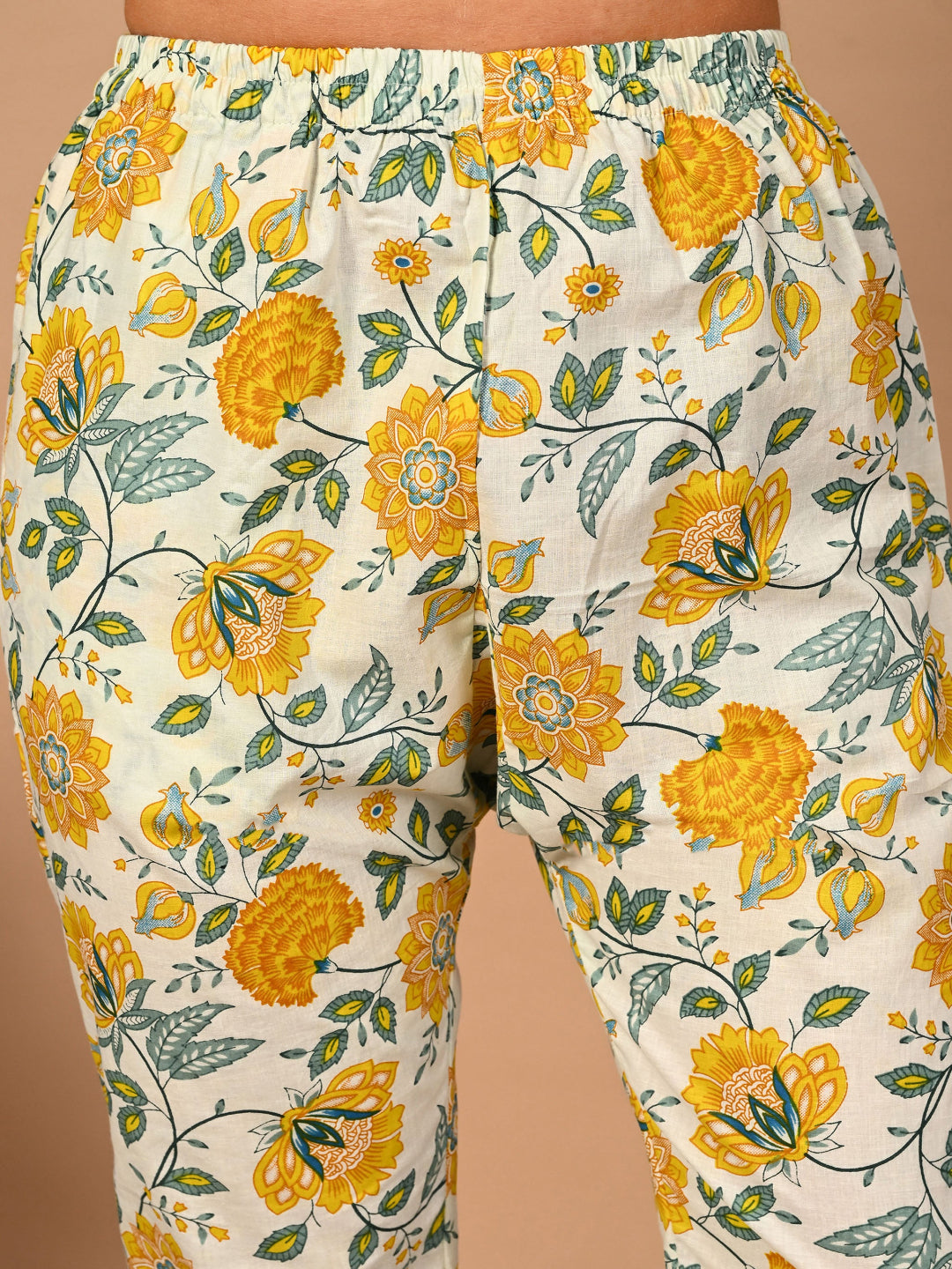 Floral-patterned pants with yellow flowers on a beige background